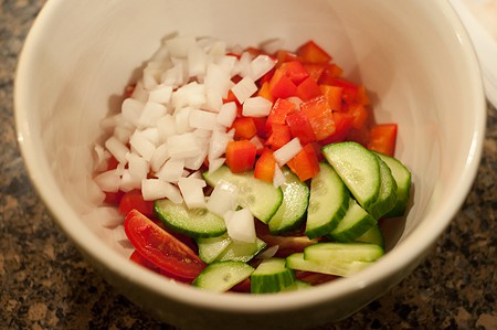 Preparing veggie garnish in a small bowl.