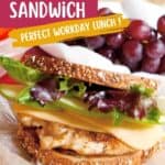 A chicken, apple, and gouda cheese sandwich with lettuce on whole grain bread sits on a plate next to a serving of red grapes. The image includes text promoting it as a perfect workday lunch.
