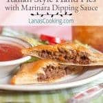Two Italian style hand pies on a plate with a small dish of marinara dipping sauce.