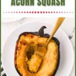 A baked acorn squash half on a white plate with a fork, ready to eat.