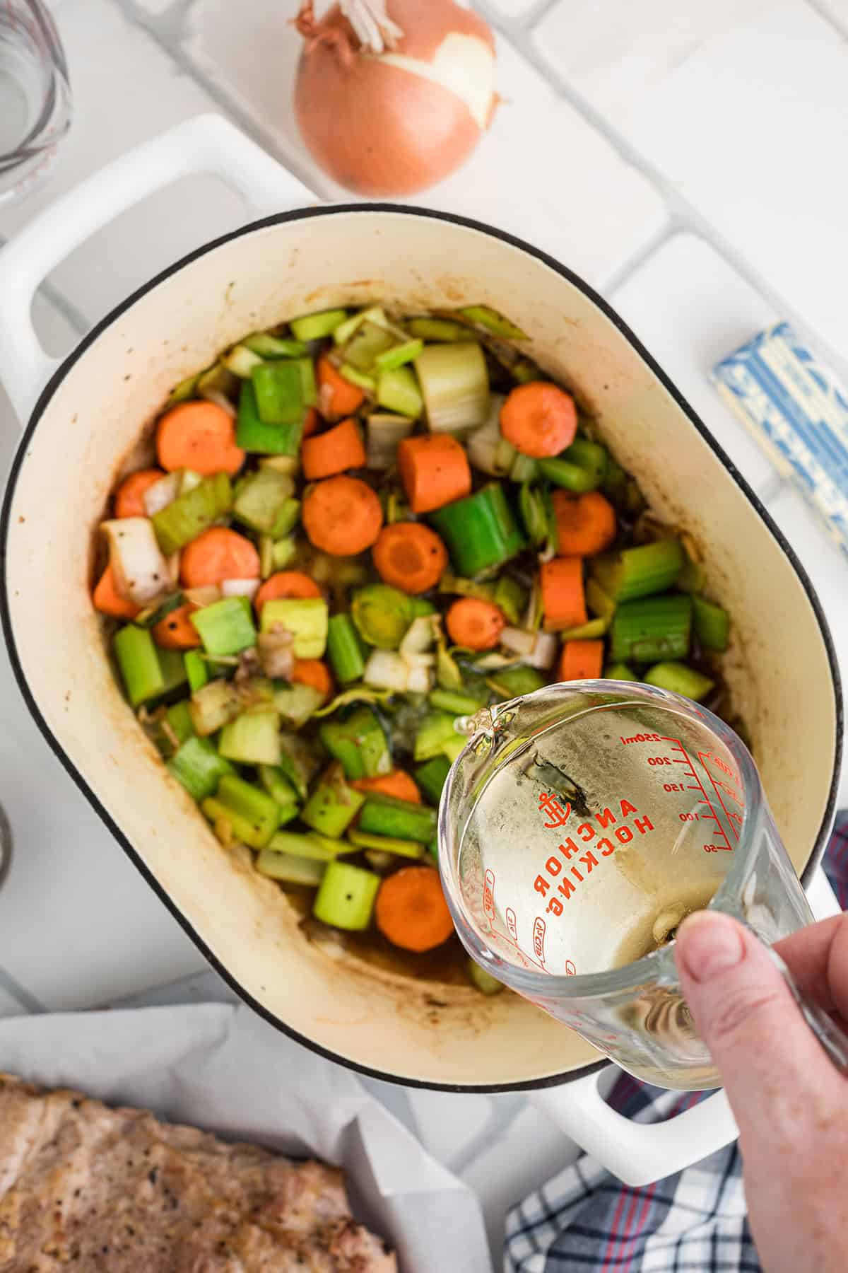 Adding wine to the vegetables.