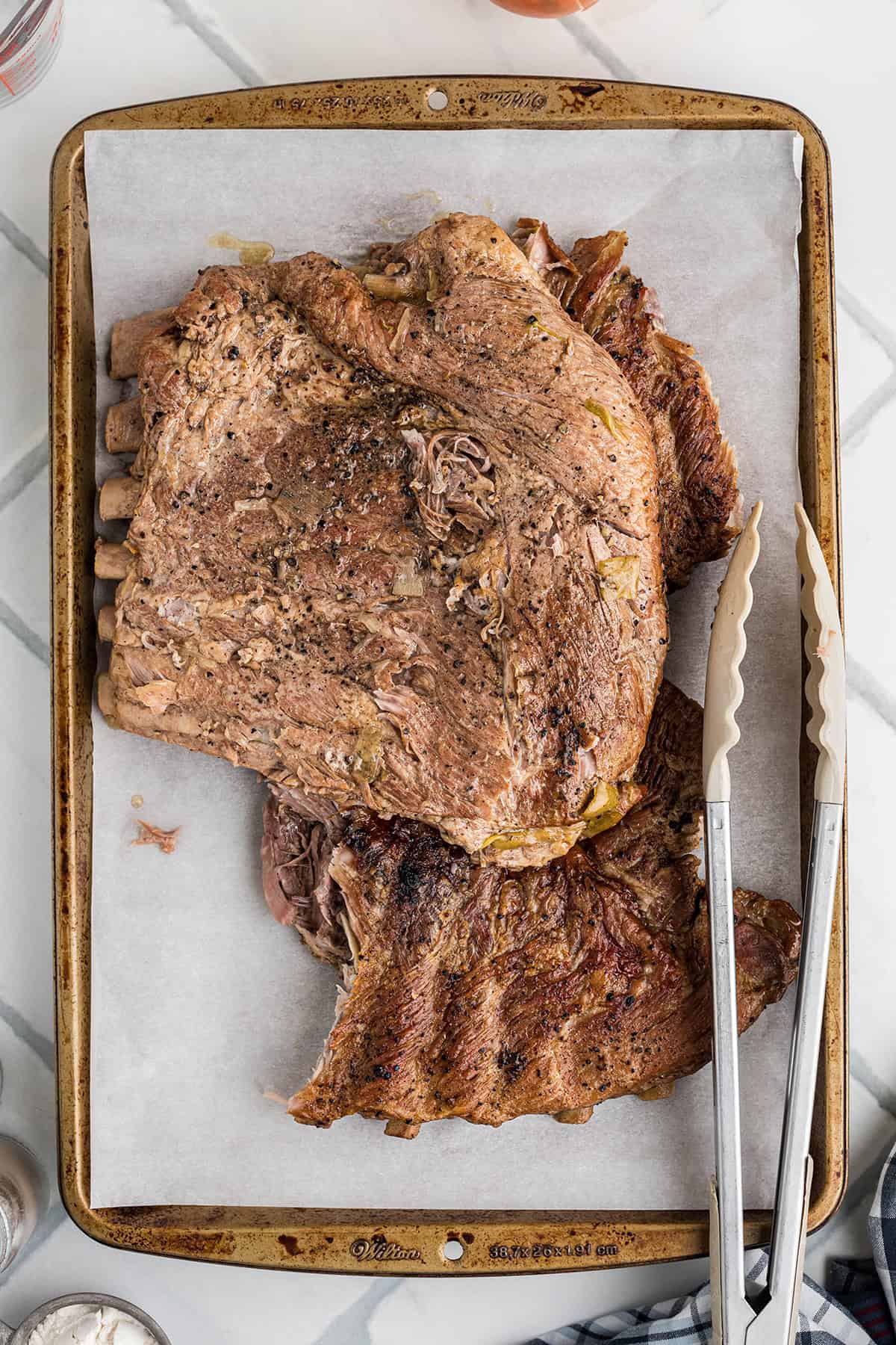 Cooked ribs on a baking sheet.