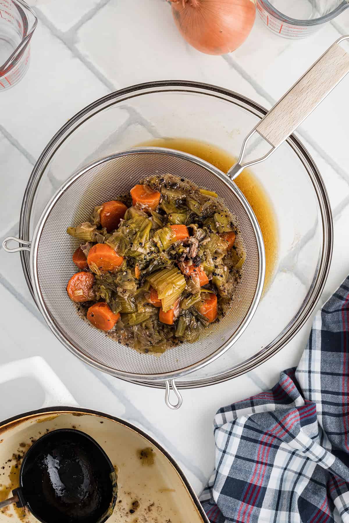 Straining the cooking liquid into a bowl.