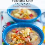 A serving of vegetable soup in a blue speckled bowl.