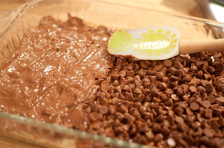 Spreading warm chocolate chips over the caramel layer.