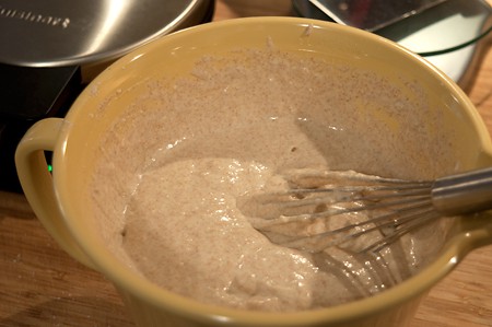 Waffle batter and a whisk in a mixing bowl.