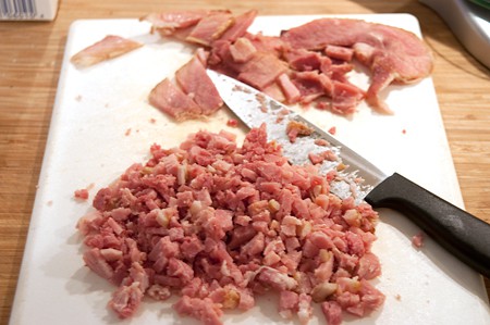 Finely minced ham on a cutting board.