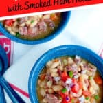Two bowls of Slow Cooker White Beans with Smoked Ham Hocks presented on a wooden board with a kitchen towel and spoons. Text overlay for pinning.
