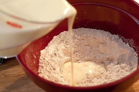 Pouring the buttermilk and egg mixture into flour in mixing bowl