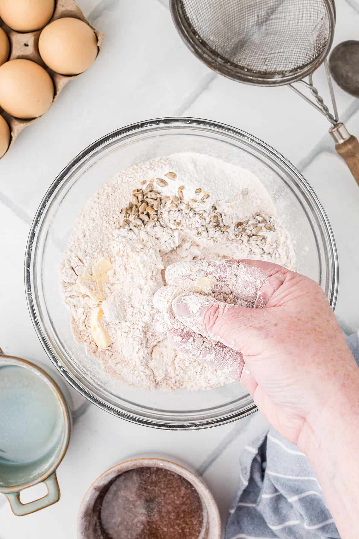 Rubbing the butter into the flour with fingers.
