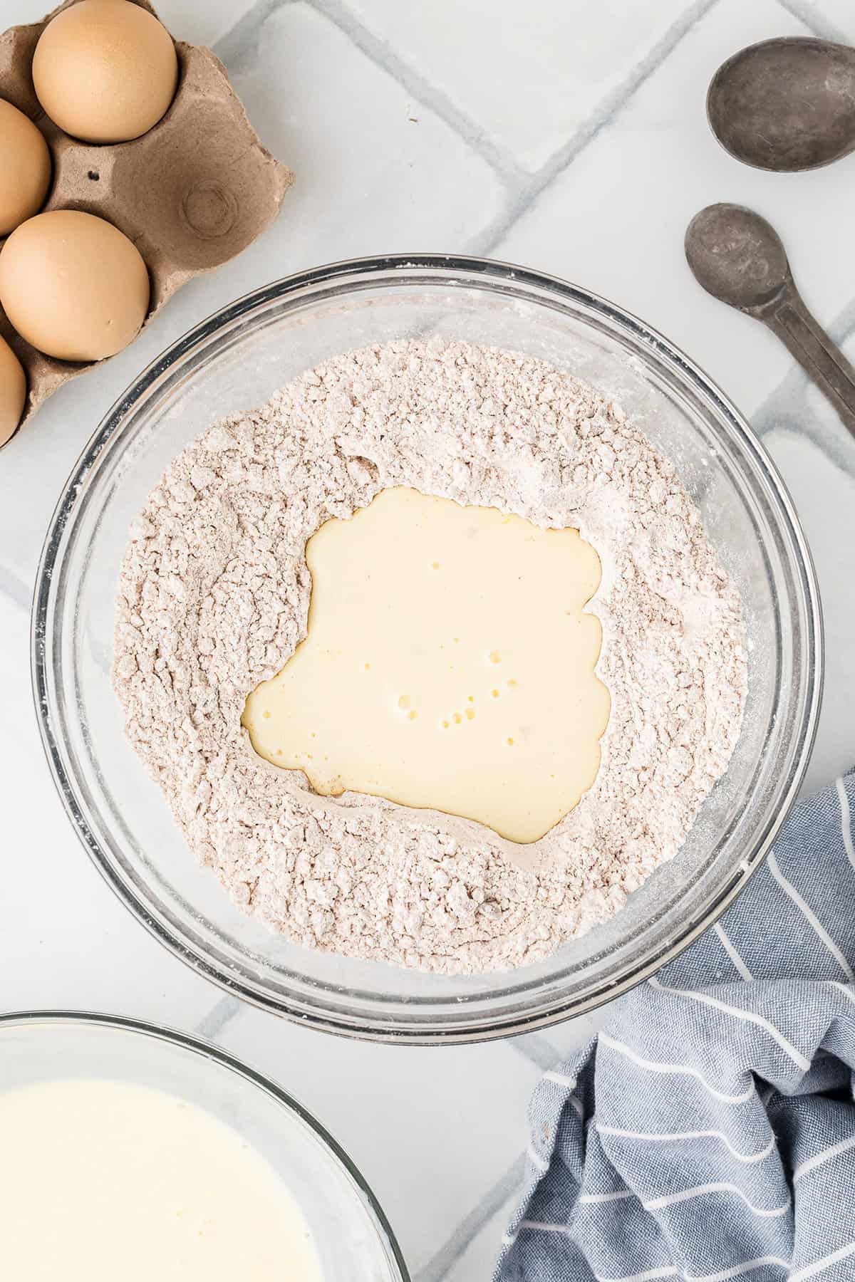 Buttermilk and egg mixture poured into a well in the flour.