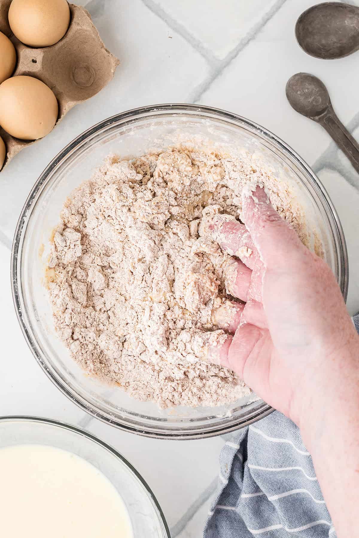 Mixing the dough using hands in a bowl.