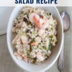 Oval dish of shrimp and rice salad with veggies, served with a fork; text reads Shrimp and Rice Salad Recipe.
