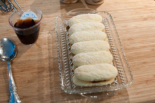 Second layer of ladyfingers added on top of toasted pecans.