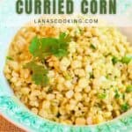 A plate of curried corn garnished with cilantro is served on a green and white dish. Text on image reads Southern Curried Corn lanascooking.com.