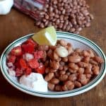 Pinto Beans with Fresh Tomato Relish - easy and simple recipe for traditional pinto beans. Served with a fresh tomato relish, sour cream, and lime wedges. https://www.lanascooking.com/pinto-beans-fresh-tomato-relish/