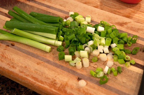 Chopped green onions on a cutting board.