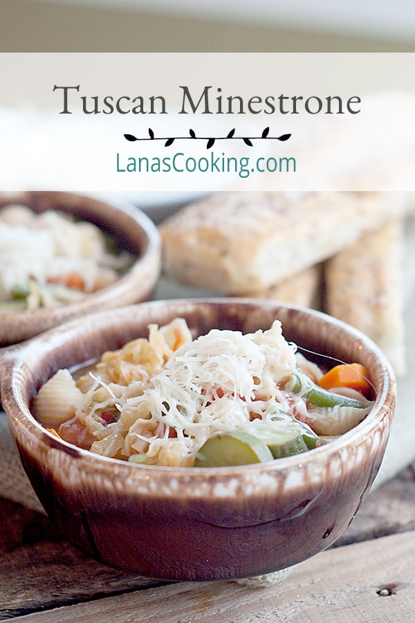 Tuscan Minestrone in serving bowls with bread sticks in the background.