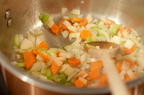 Sauteeing onions, carrots, celery, and garlic in a soup pot.