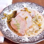 Sliced Braised Pork Loin with Creamy Celery Sauce on a serving plate.