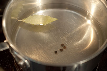 Vinegar, water, sugar, bay leaf, and peppercorns in a saucepan.