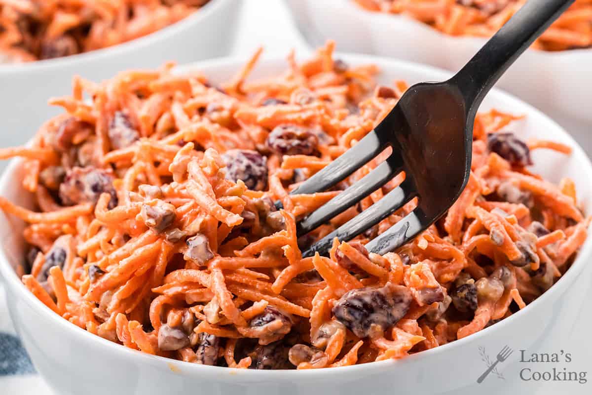 Finished carrot cranberry salad in a white serving bowl.