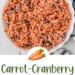 A bowl of creamy carrot and cranberry salad with grated carrots and cranberries mixed together.