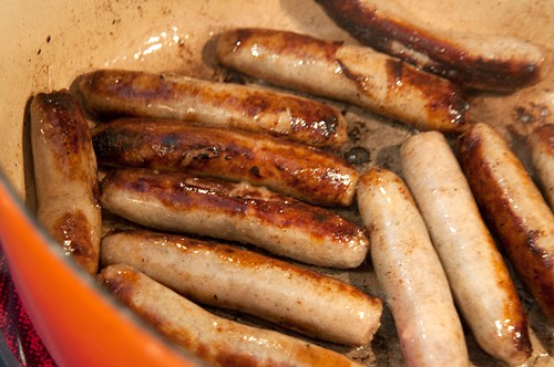 Browning sausages in a large pot.