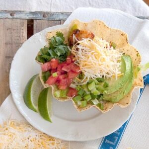 A tortilla filled with layered mexican chicken salad on a white plate.