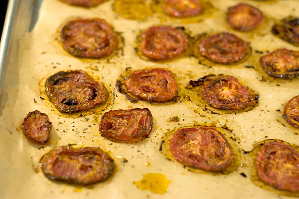 Charred tomato slices on a baking sheet.
