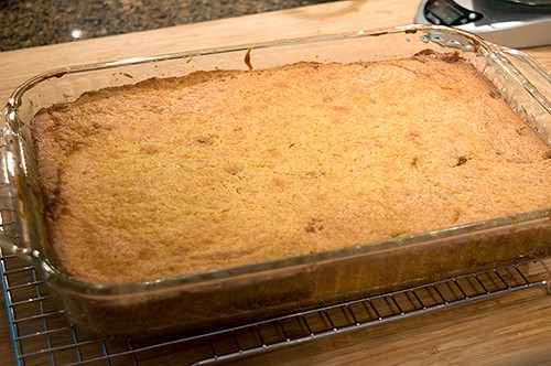 Baked cake in dish cooling on rack.