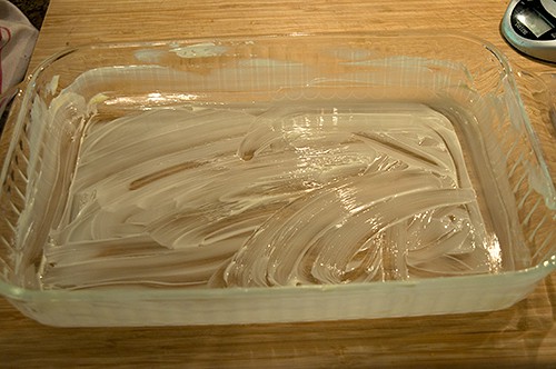 Baking pan prepared with softened butter.