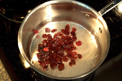 Water and dried cranberries in a small saucepan.