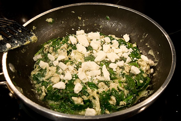 Feta added to the top of the cooked egg white mixture in the skillet.