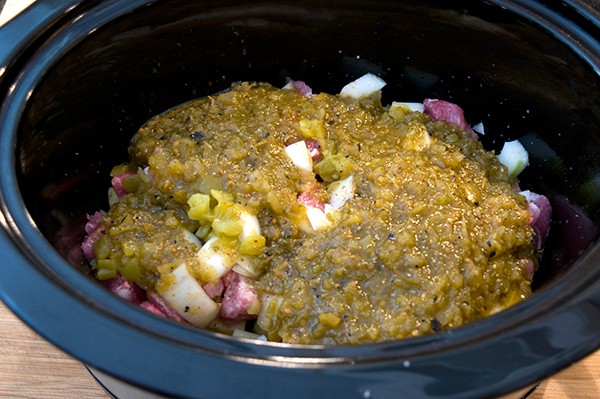 Salsa mixture poured over the ingredients in the slow cooker.