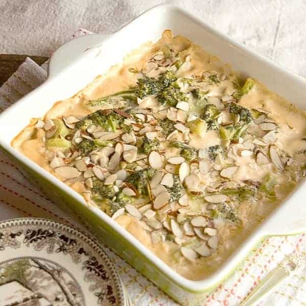 A cheesy baked broccoli casserole topped with sliced almonds. https://www.lanascooking.com/broccoli-casserole