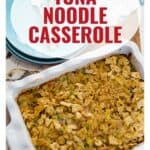 A baked tuna noodle casserole in a dish, with plates and utensils beside it. Text reads Tuna Noodle Casserole.