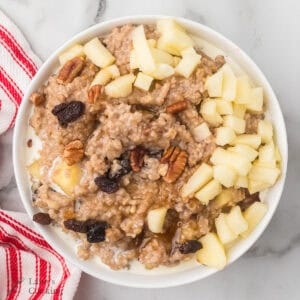 A serving of apple pie oatmeal in a white bowl.