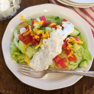 A white plate with salad and dressing.