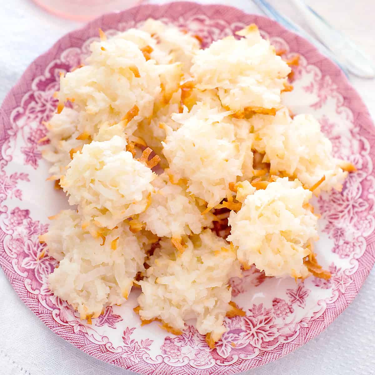 Coconut macaroons on a pink and white serving plate.