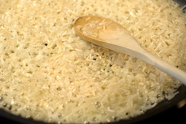 Rice cooking butter in a skillet.