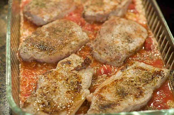 Pork chops and rice mixture in a casserole dish.