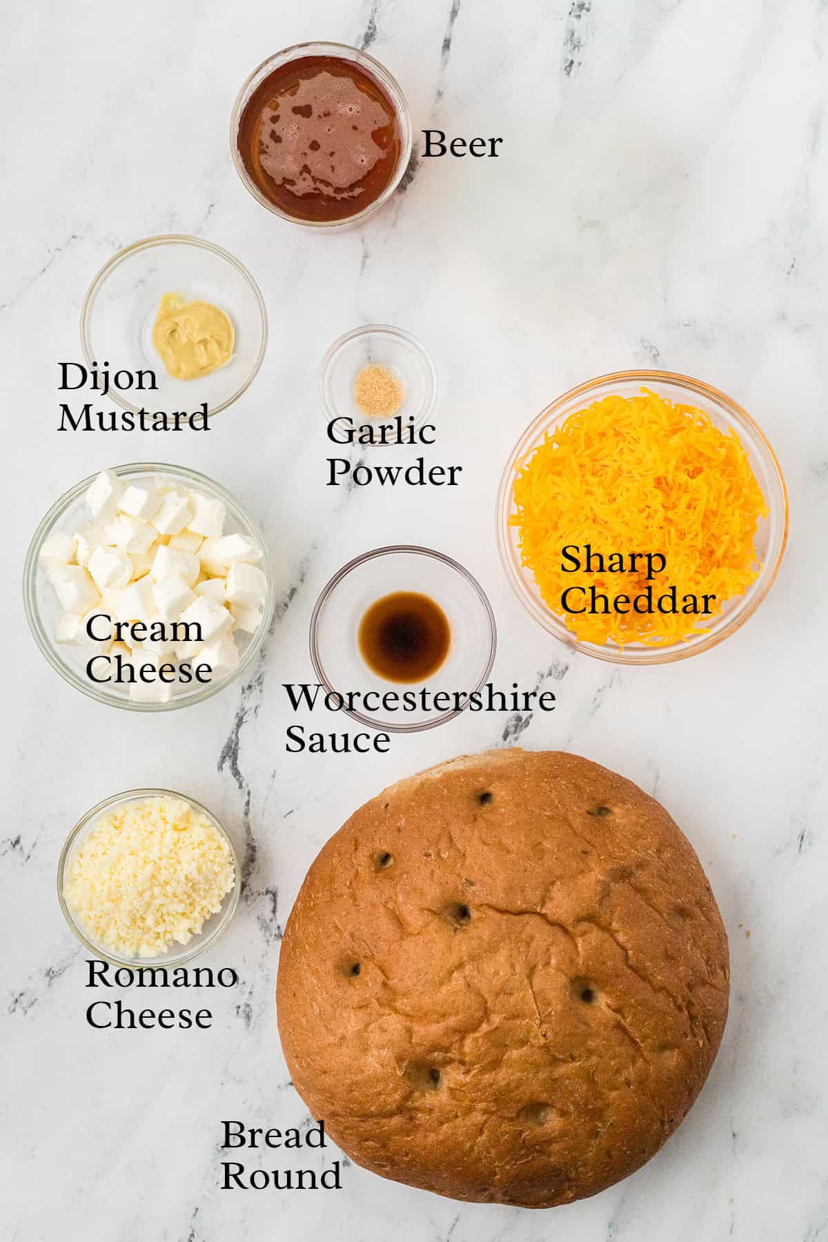 Ingredients for beer cheese dip: bread round, cream cheese, romano, cheddar, Dijon, beer, Worcestershire, garlic.