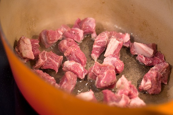 Browning the meats in a Dutch oven.