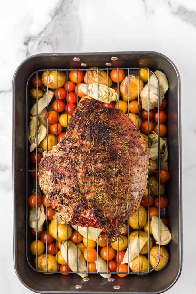 Tomatoes and artichoke hearts added to the baking pan.