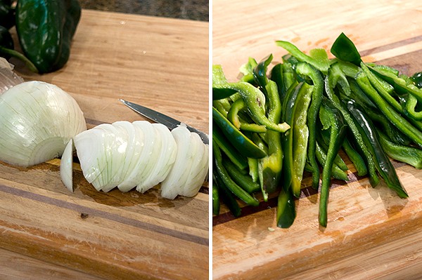 Sliced onions and poblano peppers on a cutting board.