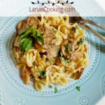 A serving of Italian sausage alfredo on a blue plate.