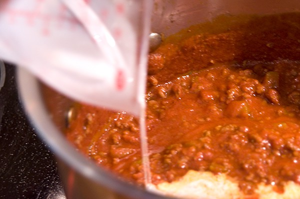 Adding half and half to sauce in skillet.