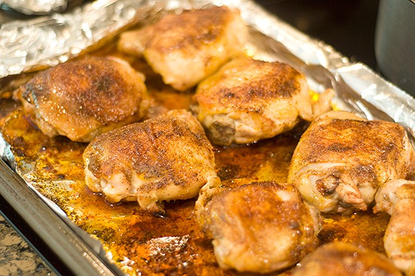 Cooked chicken thighs on baking sheet