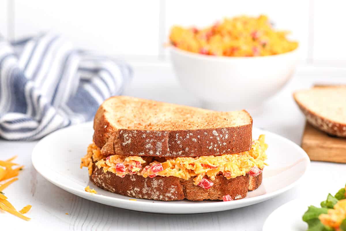 A pimiento cheese sandwich on a white serving plate.